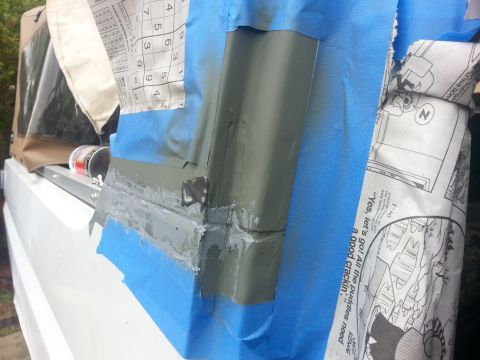 1992 Ford Bronco - Body panel repair work in progress, with masking tape and filler applied to a section of the vehicle.
