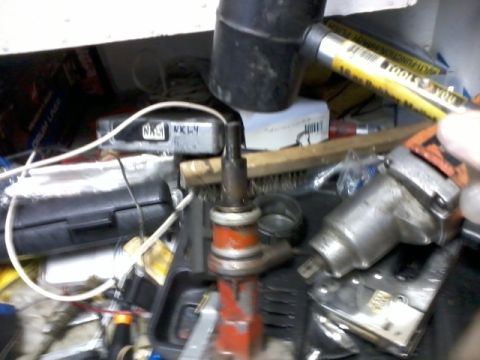 1998 Ford Crown Victoria - A close-up view of a distributor cap and rotor, surrounded by various tools and automotive parts.