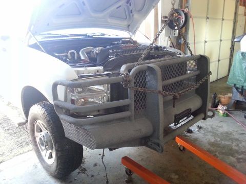 1995 Ford F-150 - Truck front end being worked on, with hood open and engine visible. A large grille guard is attached.