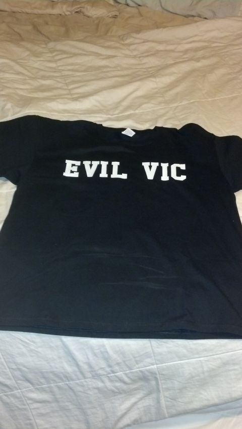 2003 Ford Crown Victoria - A black t-shirt with the words 'EVIL VIC' printed in white is displayed on a bed.