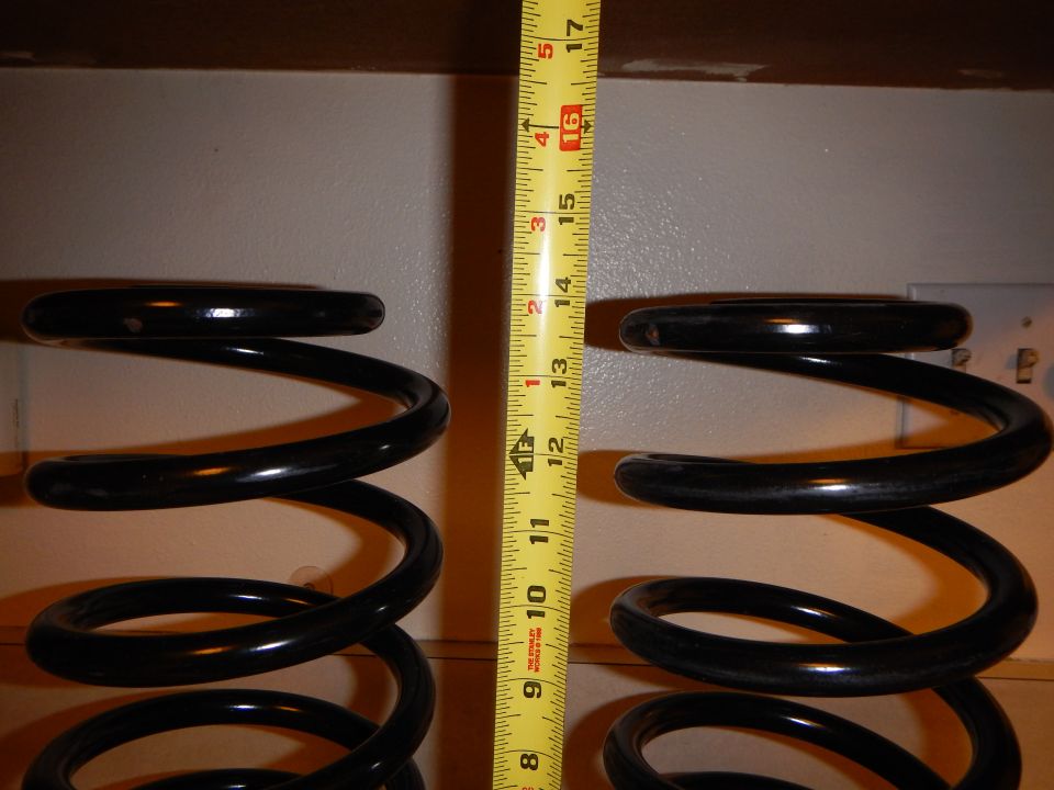 Pair of black coil springs on shelf with yellow tape measure showing 16 inches
