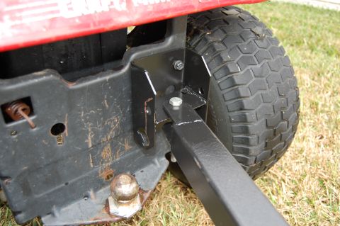 2006 Honda RANCHER - Close-up of a red lawn tractor's rear hitch assembly and tire.