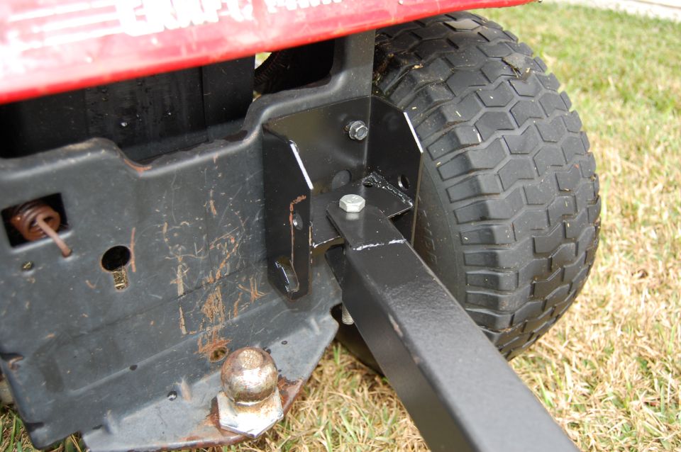 Red lawn tractor rear hitch assembly with ball mount and tire