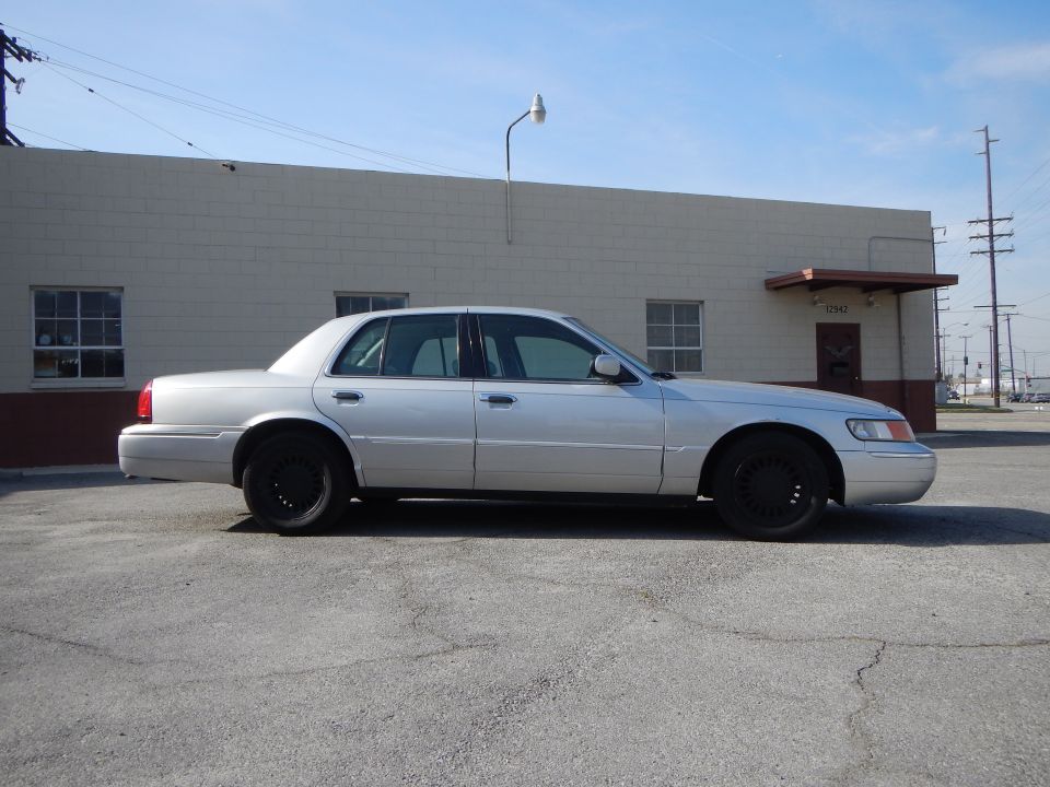 2002 Mercury Grand Marquis, side view, silver paint, black wheels, parked on asphalt