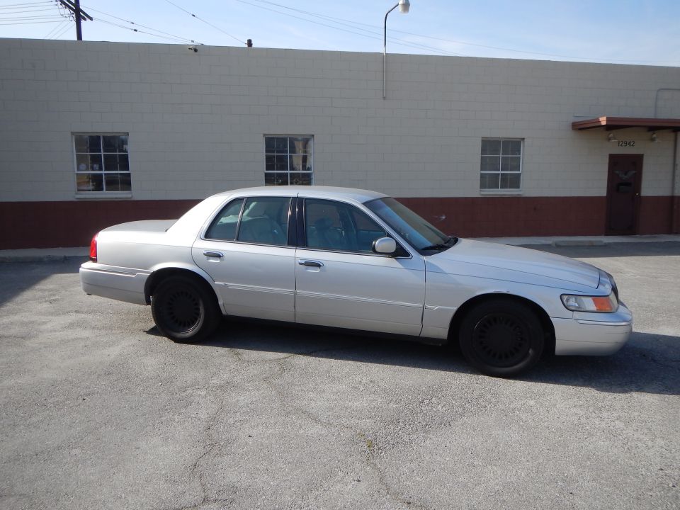 Silver 2002 Mercury Grand Marquis parked outside a building