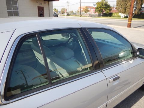 2002 Mercury Grand Marquis - A silver sedan is parked outside a building. The interior and side profile of the car are visible.