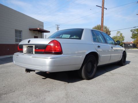 2002 Mercury Grand Marquis - Rear 3/4 view of a silver 2002 Mercury Grand Marquis with black wheels parked outdoors.