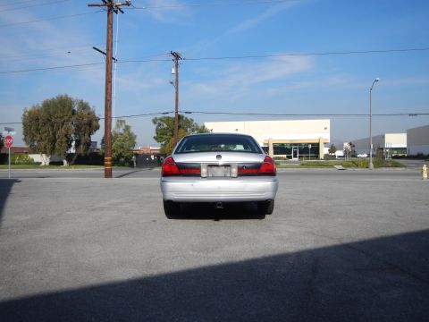 2002 Mercury Grand Marquis - Rear view of a silver 2002 Mercury Grand Marquis parked in an asphalt lot with buildings in the background.