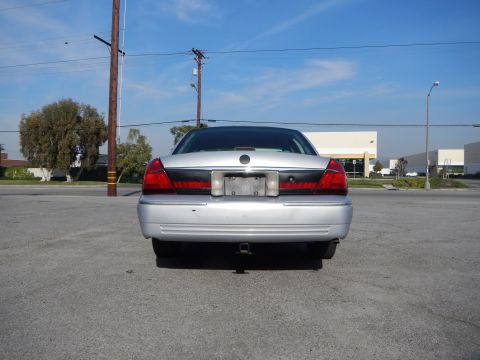 2002 Mercury Grand Marquis - Rear view of a silver 2002 Mercury Grand Marquis parked in an industrial area.