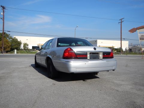 2002 Mercury Grand Marquis - Rear view of a silver 2002 Mercury Grand Marquis sedan parked outdoors under a clear blue sky.