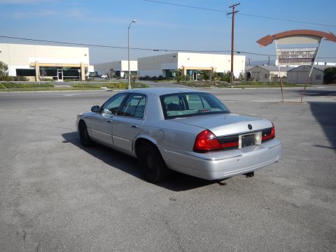 2002 Mercury Grand Marquis - Silver 2002 Mercury Grand Marquis seen from the rear in a parking lot with industrial buildings in the background.