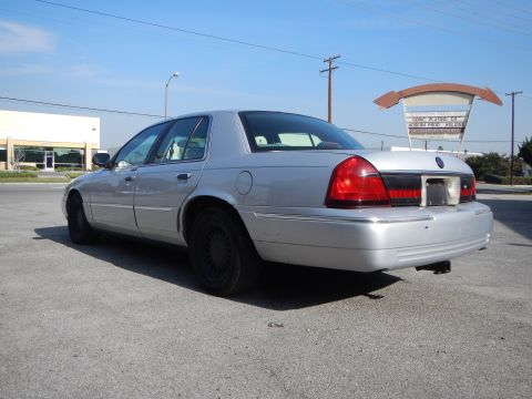 2002 Mercury Grand Marquis - A silver 2002 Mercury Grand Marquis is parked outdoors under a clear blue sky.