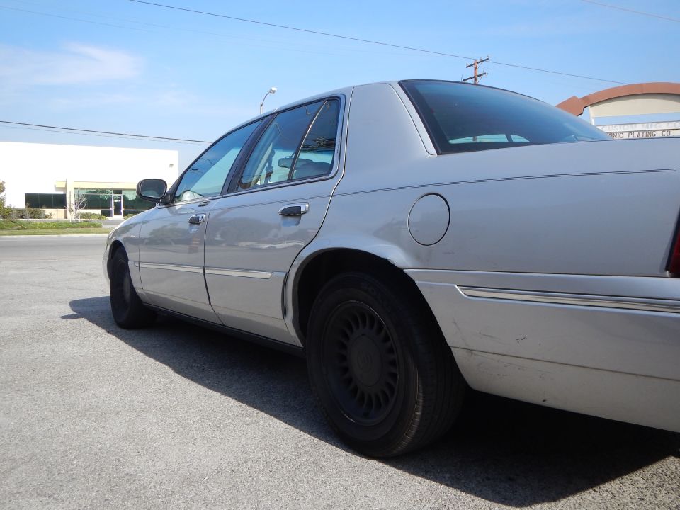 Silver sedan parked on asphalt, rear quarter panel and side visible. Black wheels