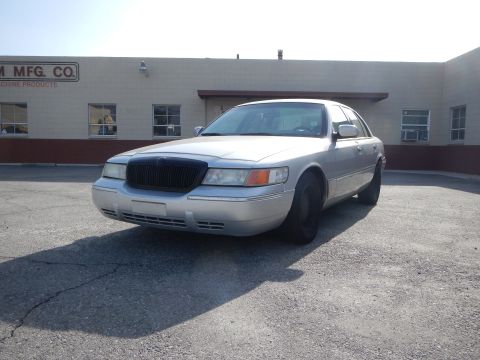 2002 Mercury Grand Marquis - Silver 2002 Mercury Grand Marquis parked in front of a commercial building.