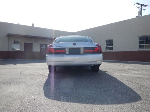 2002 Mercury Grand Marquis - Rear view of a silver 2002 Mercury Grand Marquis parked in front of a building.