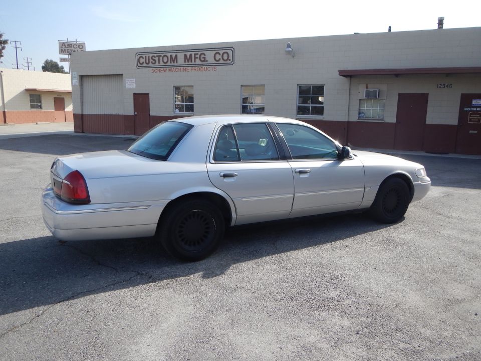 Silver 2002 Mercury Grand Marquis parked outside Custom Mfg. Co