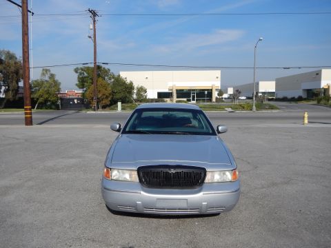 2002 Mercury Grand Marquis - Front view of a silver 2002 Mercury Grand Marquis parked in a lot with commercial buildings in the background.