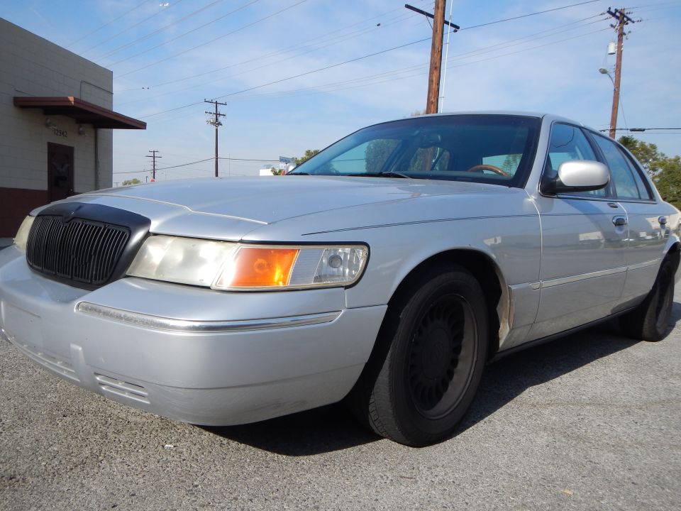 Silver 2002 Mercury Grand Marquis parked outside a building
