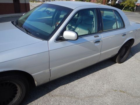 2002 Mercury Grand Marquis - Side view of a silver 2002 Mercury Grand Marquis sedan parked on asphalt.
