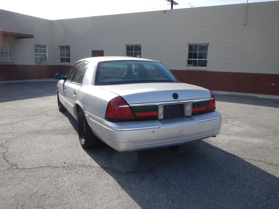 Silver 2002 Mercury Grand Marquis parked outside a building