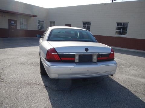 2002 Mercury Grand Marquis - Rear view of a silver 2002 Mercury Grand Marquis parked in front of a commercial building.