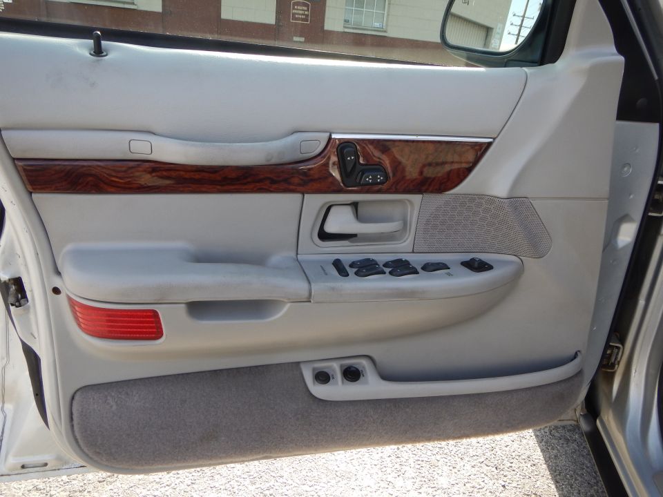 Interior door panel of a 2002 Mercury Grand Marquis showing power window and seat controls