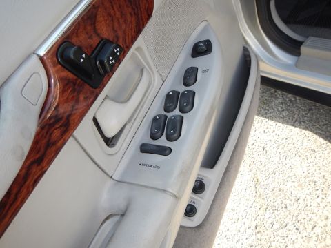 2002 Mercury Grand Marquis - Close-up of the interior door panel, showing wood trim and power controls for windows and locks.