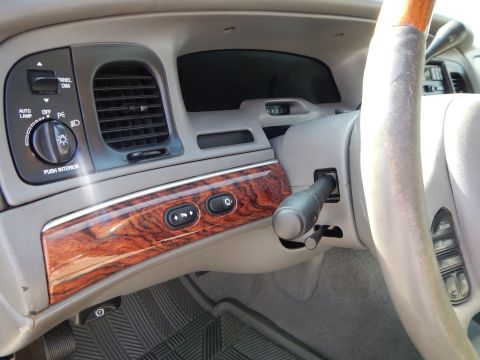 2002 Mercury Grand Marquis - The interior of a car, the dashboard with wood grain trim and a view of the steering wheel and air vents.