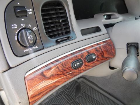2002 Mercury Grand Marquis - Interior view of a 2002 Mercury Grand Marquis, highlighting the wood-grain trim, headlight controls, and dashboard air vents.