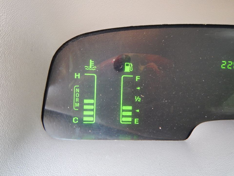 Dashboard gauges showing fuel and temperature levels, with a digital readout of 225