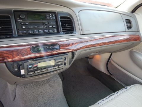 2002 Mercury Grand Marquis - The interior of a 2002 Mercury Grand Marquis features wood grain trim and a digital climate control display.