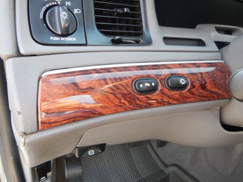 2002 Mercury Grand Marquis - Interior view of a 2002 Mercury Grand Marquis dashboard, highlighting wood trim and control buttons.