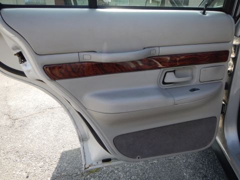 2002 Mercury Grand Marquis - Interior view of a white car door panel, showing the armrest, door handle, and wood grain trim.
