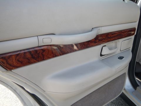 2002 Mercury Grand Marquis - Interior door panel detail on a 2002 Mercury Grand Marquis, showing wood trim and armrest.