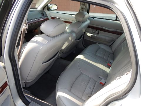 2002 Mercury Grand Marquis - The interior of a 2002 Mercury Grand Marquis shows light gray leather seats and wood trim details.