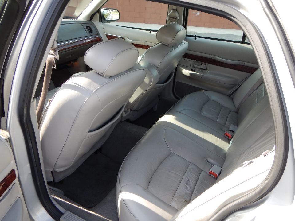 2002 Mercury Grand Marquis interior, light gray leather seats, wood trim, rear passenger view