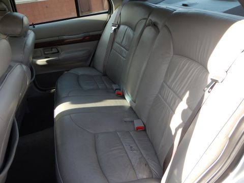 2002 Mercury Grand Marquis - Rear interior view of a 2002 Mercury Grand Marquis, showing the gray leather seats and door panel.