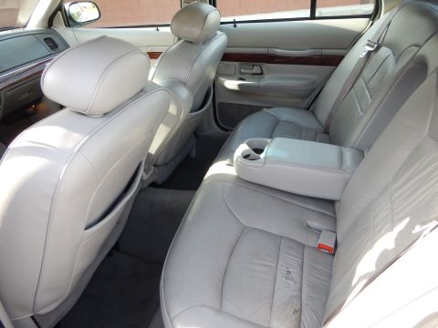 2002 Mercury Grand Marquis - The spacious rear interior of a 2002 Mercury Grand Marquis features light leather seats and wood accents.