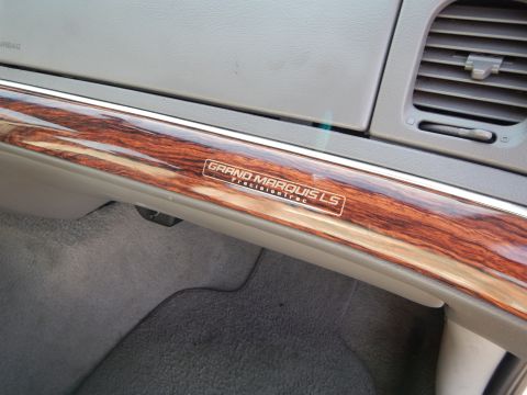 2002 Mercury Grand Marquis - Close-up of the wood grain interior trim and Grand Marquis LS badge on the dashboard.