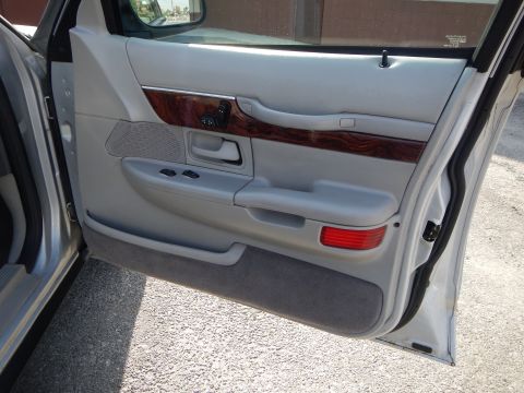 2002 Mercury Grand Marquis - Interior door panel of a 2002 Mercury Grand Marquis, wood grain trim and power controls.