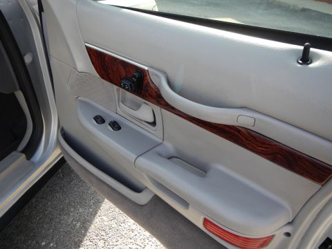 2002 Mercury Grand Marquis - Interior door panel detail on a 2002 Mercury Grand Marquis, wood grain trim and window controls.