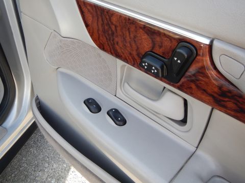 2002 Mercury Grand Marquis - The interior door panel features wood grain trim and controls for windows and power seats.