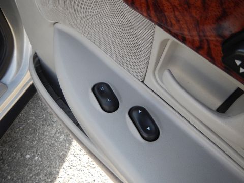 2002 Mercury Grand Marquis - Close-up of the interior door panel, showing window controls and wood grain trim on a 2002 Mercury Grand Marquis.