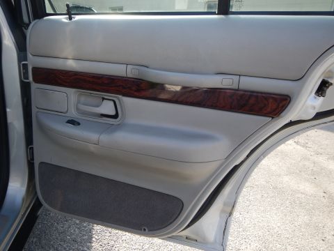 2002 Mercury Grand Marquis - Interior view of a 2002 Mercury Grand Marquis door panel, showing wood trim and speaker grille.