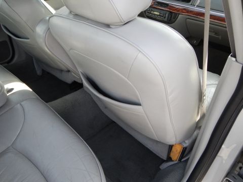 2002 Mercury Grand Marquis - Rear interior view of a 2002 Mercury Grand Marquis, showing the light gray leather seats and carpeting.