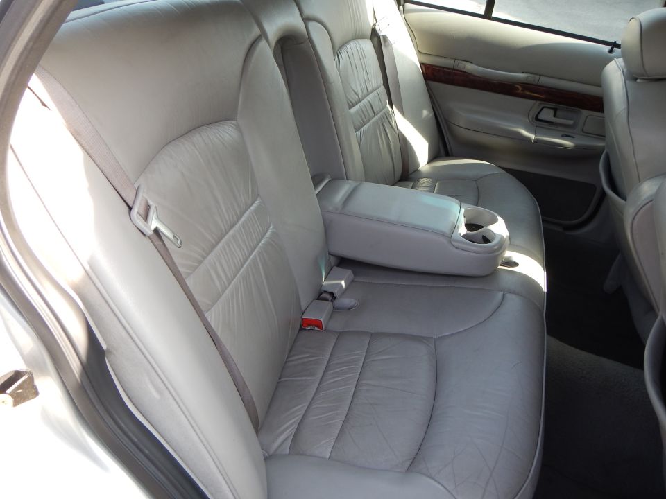 Rear leather seats and armrest with cup holders inside a car