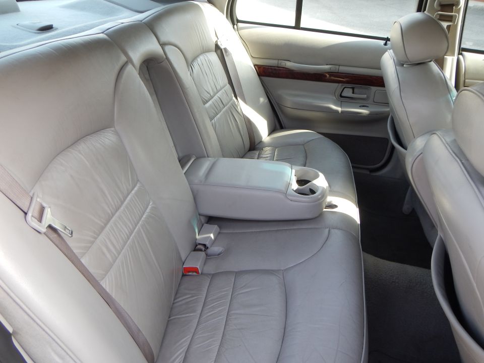 Light gray leather interior of a 2002 Mercury Grand Marquis, showing the rear seats and armrest