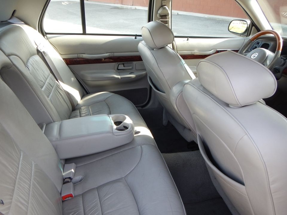 Light gray leather interior of a 2002 Mercury Grand Marquis, showing rear seats and dashboard