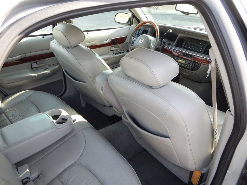 Interior view of a 2002 Mercury Grand Marquis showing front seats, dashboard, and wood trim