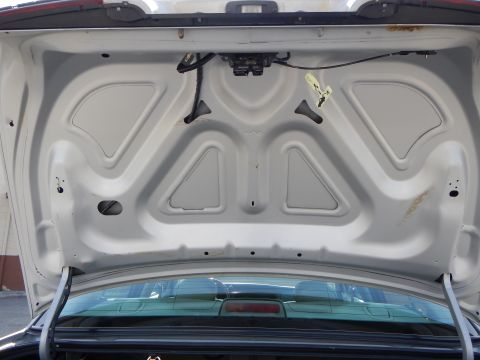 2002 Mercury Grand Marquis - The interior of the trunk of a 2002 Mercury Grand Marquis shows the latch mechanism and structural supports.